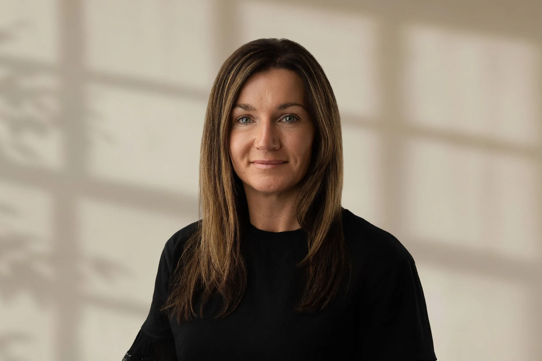 Lena Farnell looking at camera wearing a black top with straight light brown hair and a neutral expression