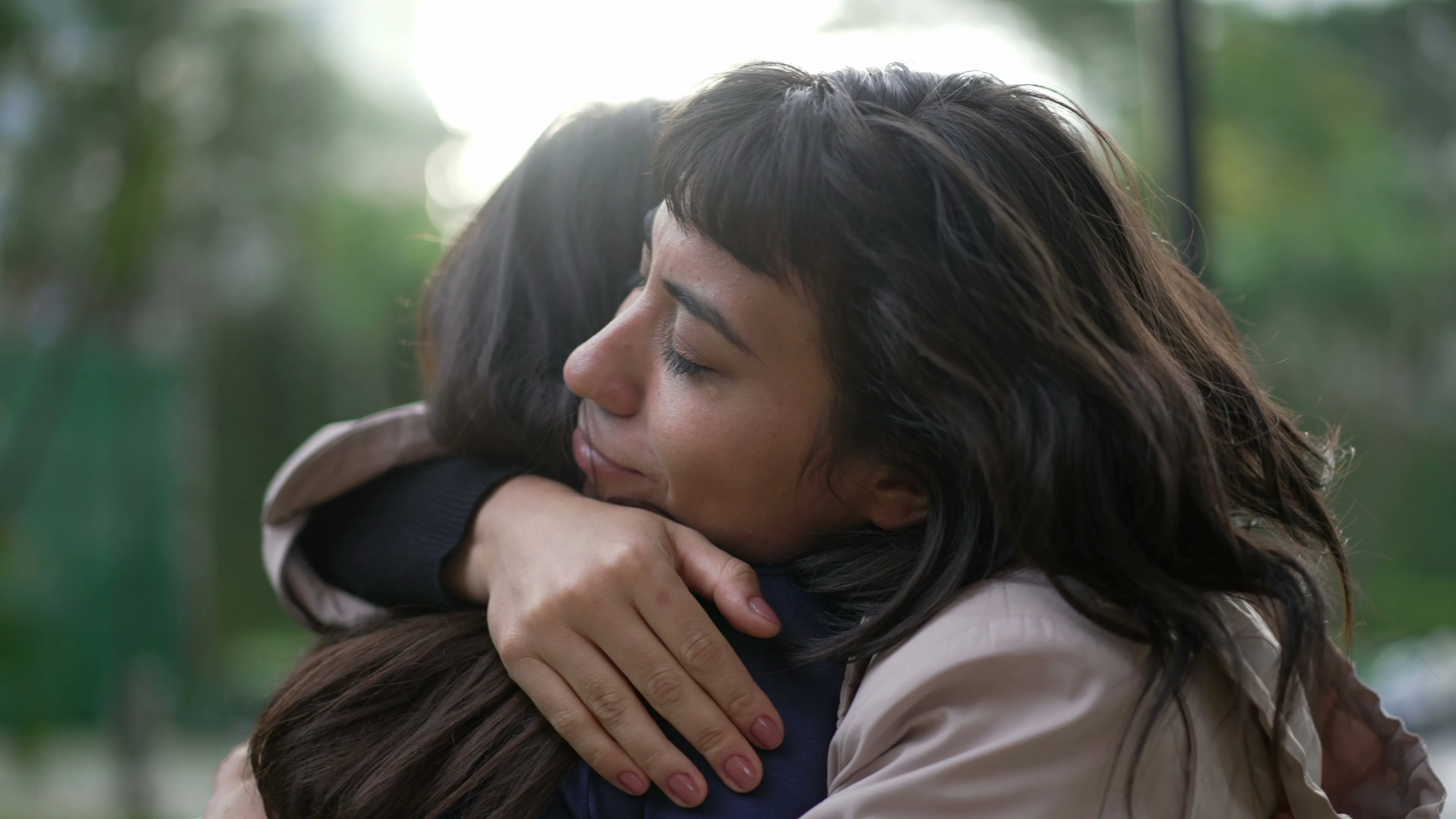 Two women embracing outdoors in a comforting hug