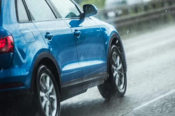 Blue car driving in rain