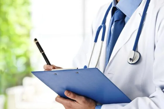 Clinician holding clipboard during medical appointment