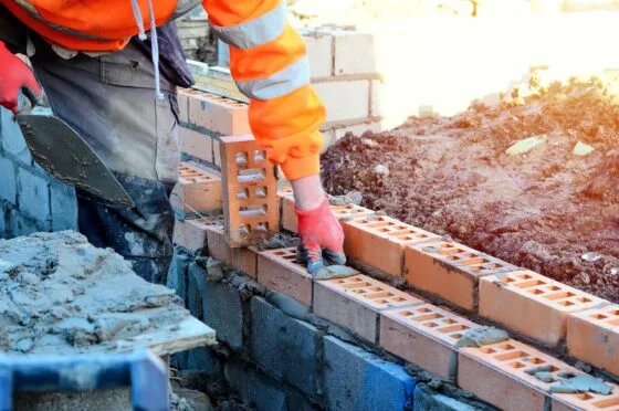 Construction worker laying bricks on site
