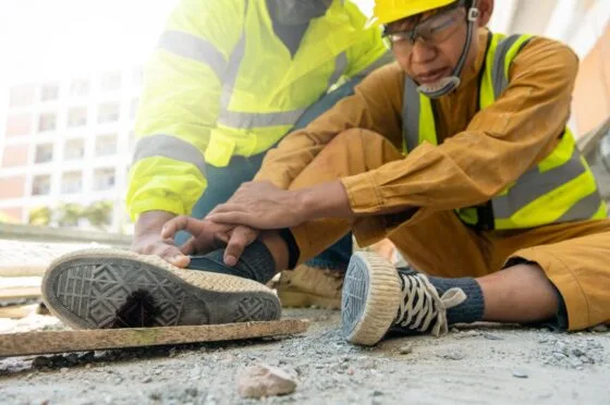Construction workers helping injured colleague