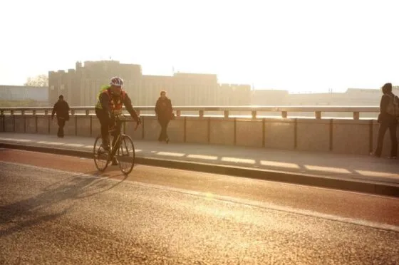 Cyclist riding over bridge at sunset