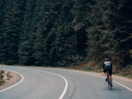 Cyclist riding through forest bend