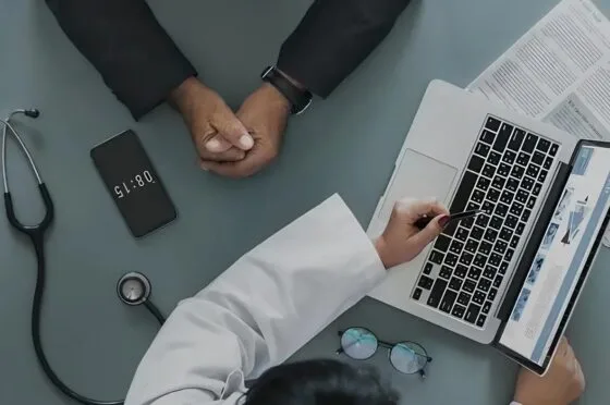 Doctor reviewing medical notes at consultation