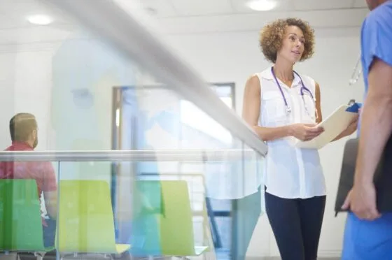 Doctor speaking with patient in hospital waiting area