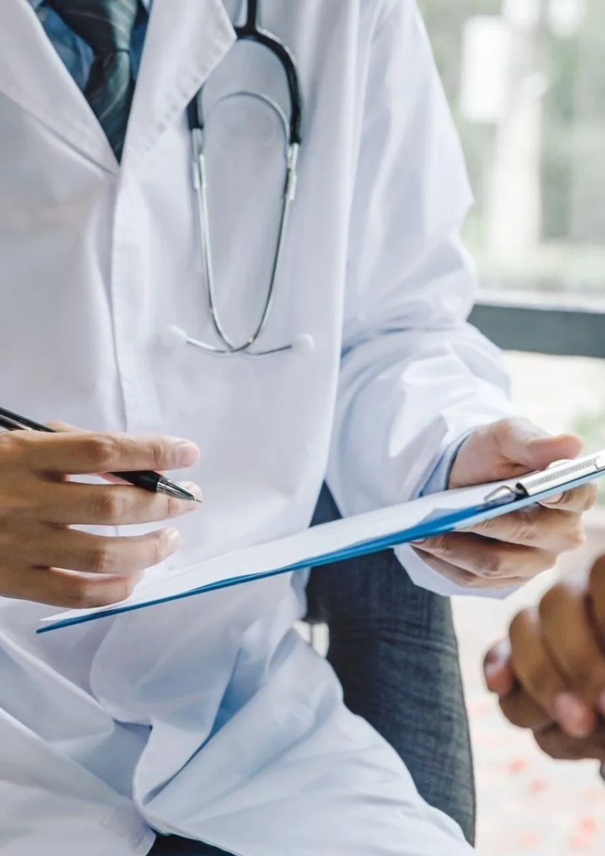 Doctor taking notes during patient consultation