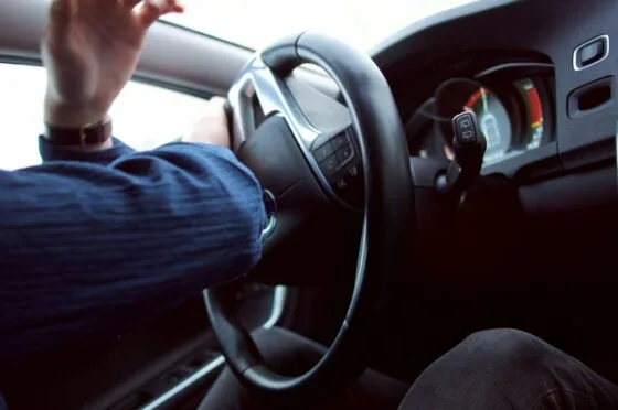 Driver holding steering wheel on road