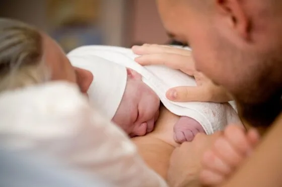 Father resting hand on newborn baby
