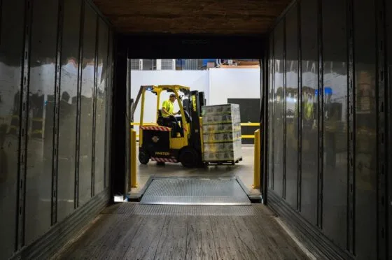 Forklift loading pallets inside lorry