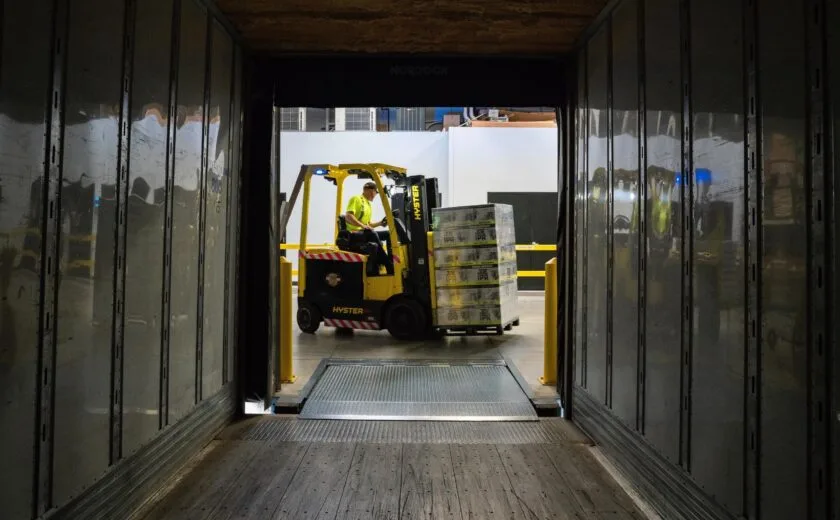 Forklift loading pallets inside lorry