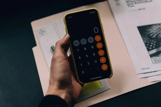 Hand using calculator on smartphone