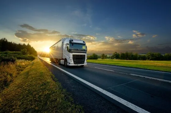 HGV driving along road at sunset