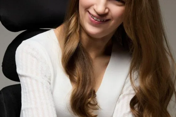 Holly seated in wheelchair smiling