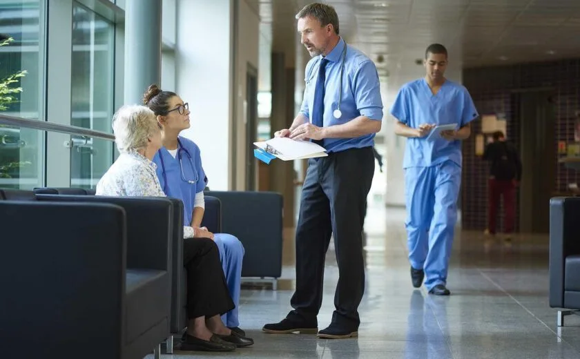 Hospital staff discussing patient care in corridor