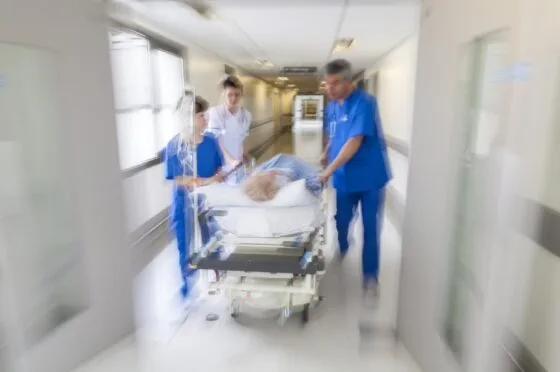 Hospital team moving patient through corridor