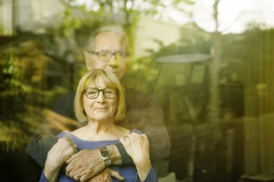 Husband and wife looking through window