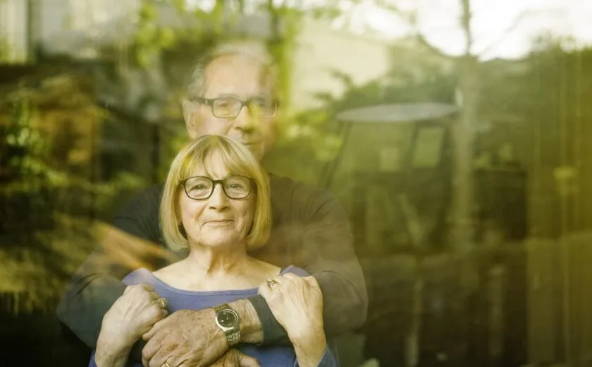 Husband and wife looking through window