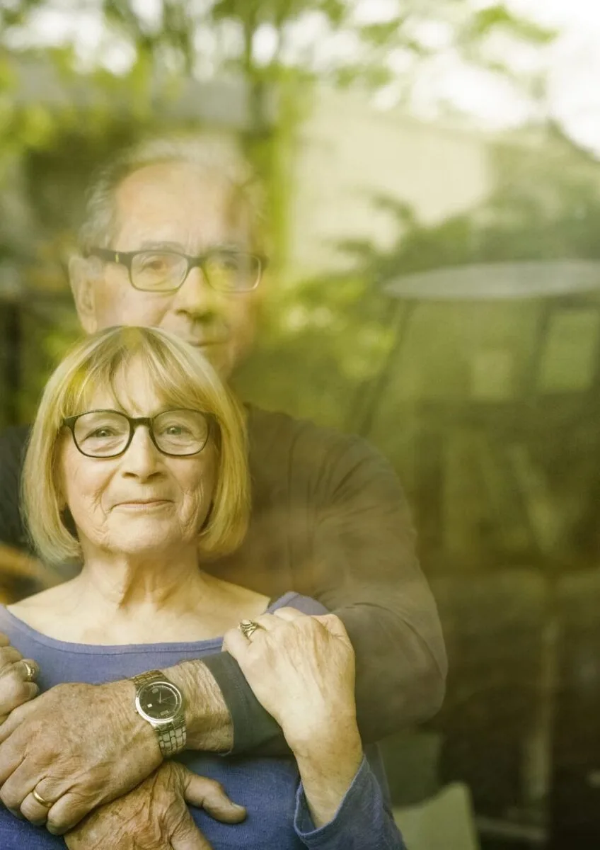 Husband and wife looking through window