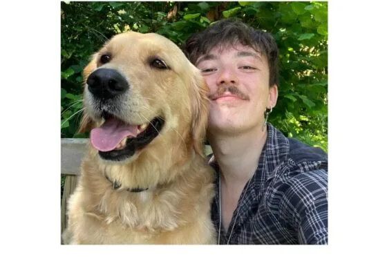 Jay smiling with assistance dog