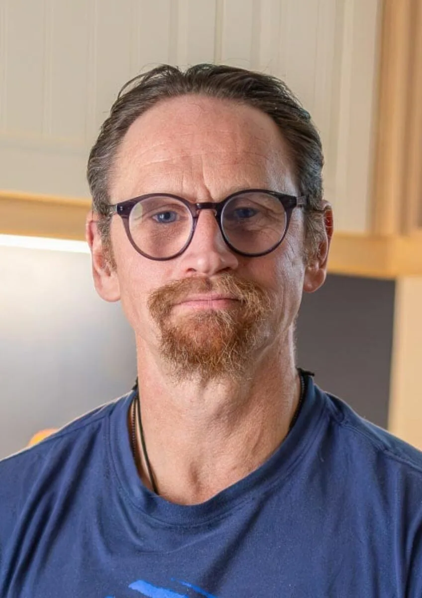 Ian Westmoreland with glasses seated in kitchen