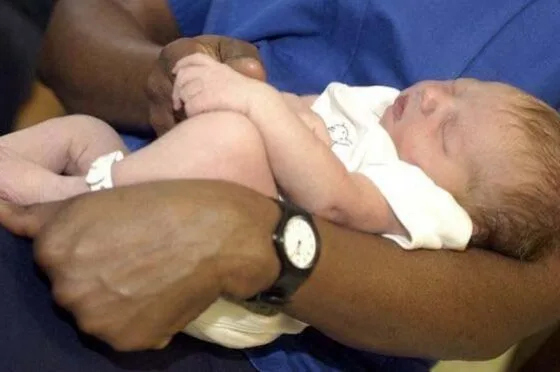 Midwife caring for newborn baby in hospital