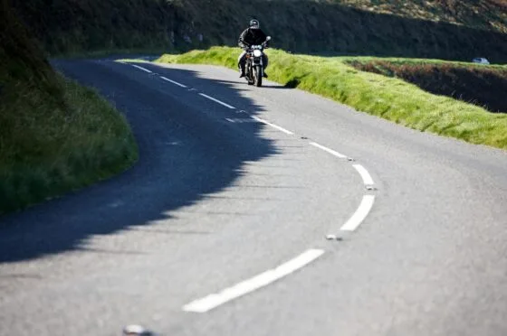 Motorcyclist riding along winding road