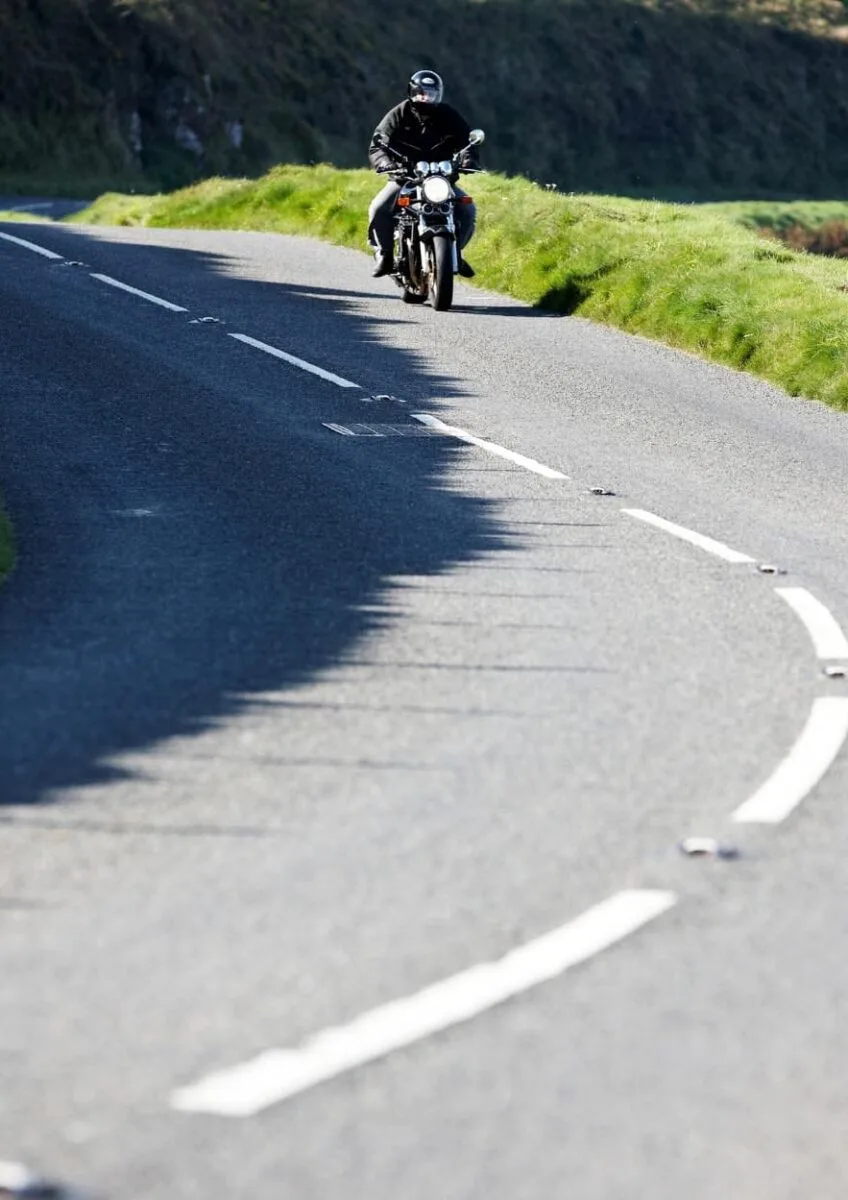 Motorcyclist riding along winding road