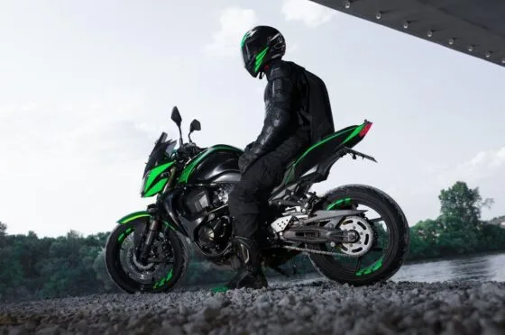 Motorcyclist seated on green motorcycle