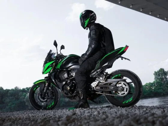 Motorcyclist seated on green motorcycle