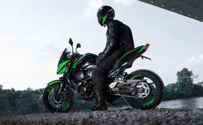 Motorcyclist seated on green motorcycle