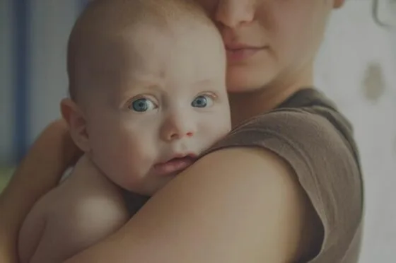 Parent holding baby against shoulder