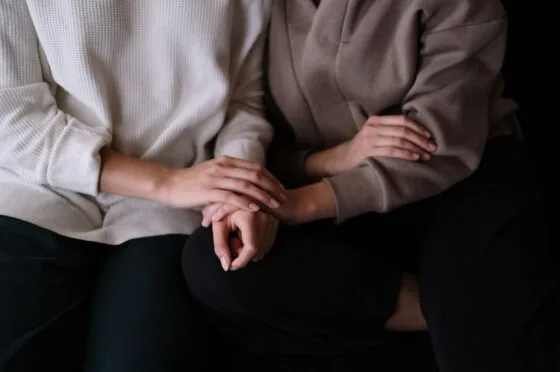 People holding hands on sofa