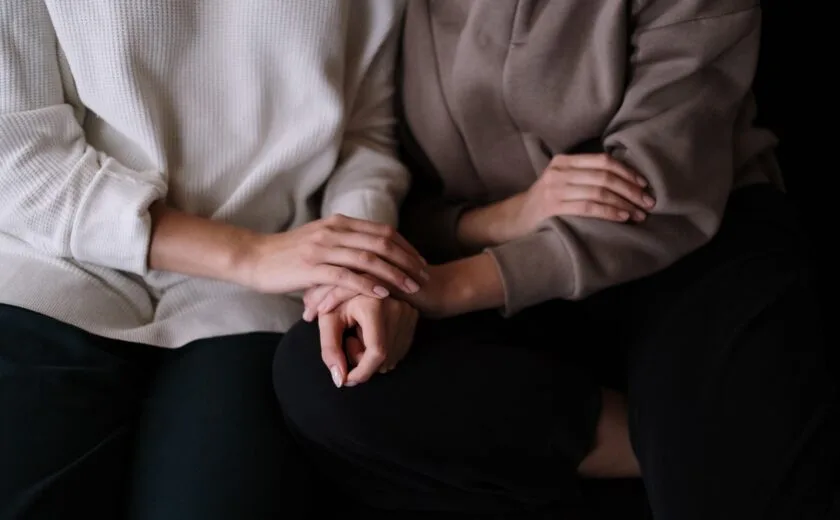 People holding hands on sofa