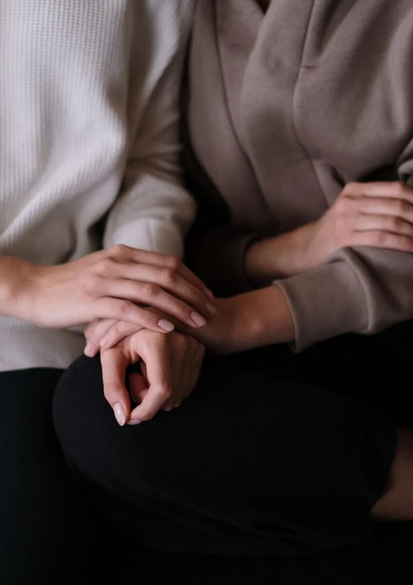People holding hands on sofa
