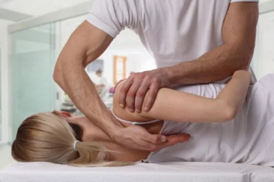 Physiotherapist stretching child's arm