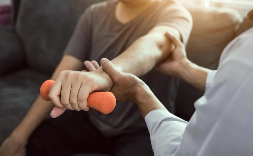 Physiotherapist supporting hand therapy exercise