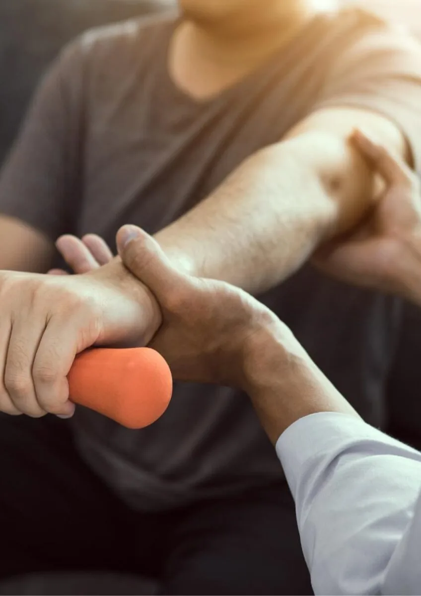 Physiotherapist supporting hand therapy exercise