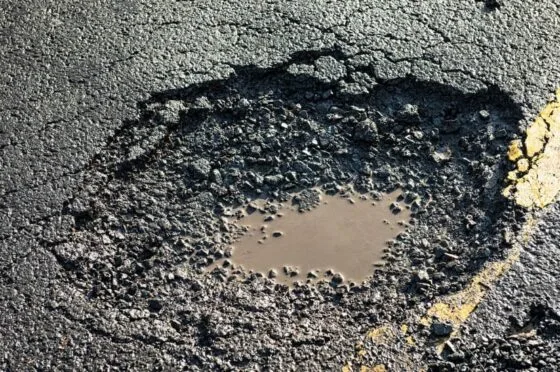 Pothole in damaged road surface