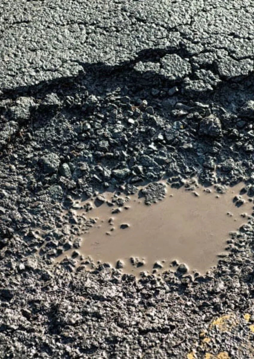 Pothole in damaged road surface