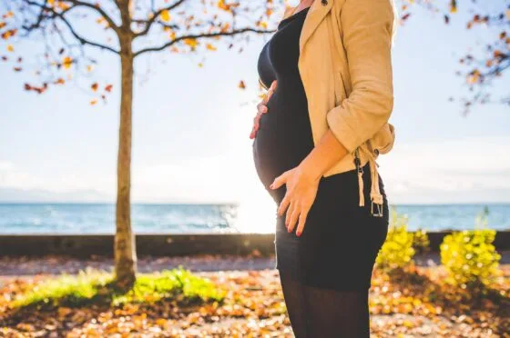 Pregnant woman standing in autumn park