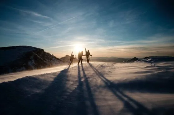 Skiers crossing snowy mountain ridge