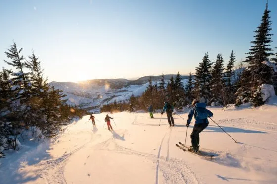 Skiers descending snowy mountain slope