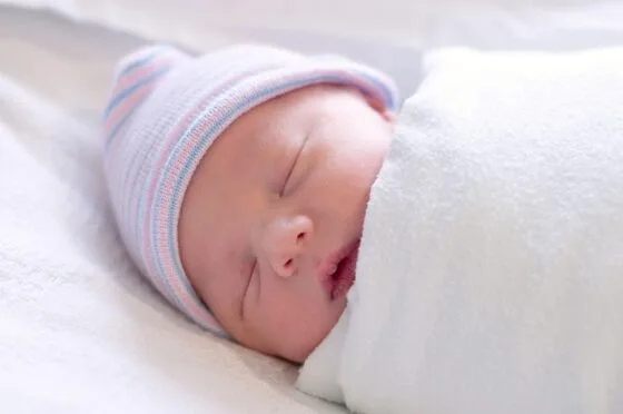 Sleeping newborn wrapped in blanket