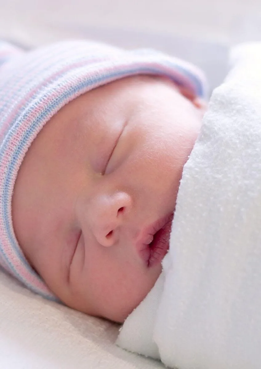 Sleeping newborn wrapped in blanket