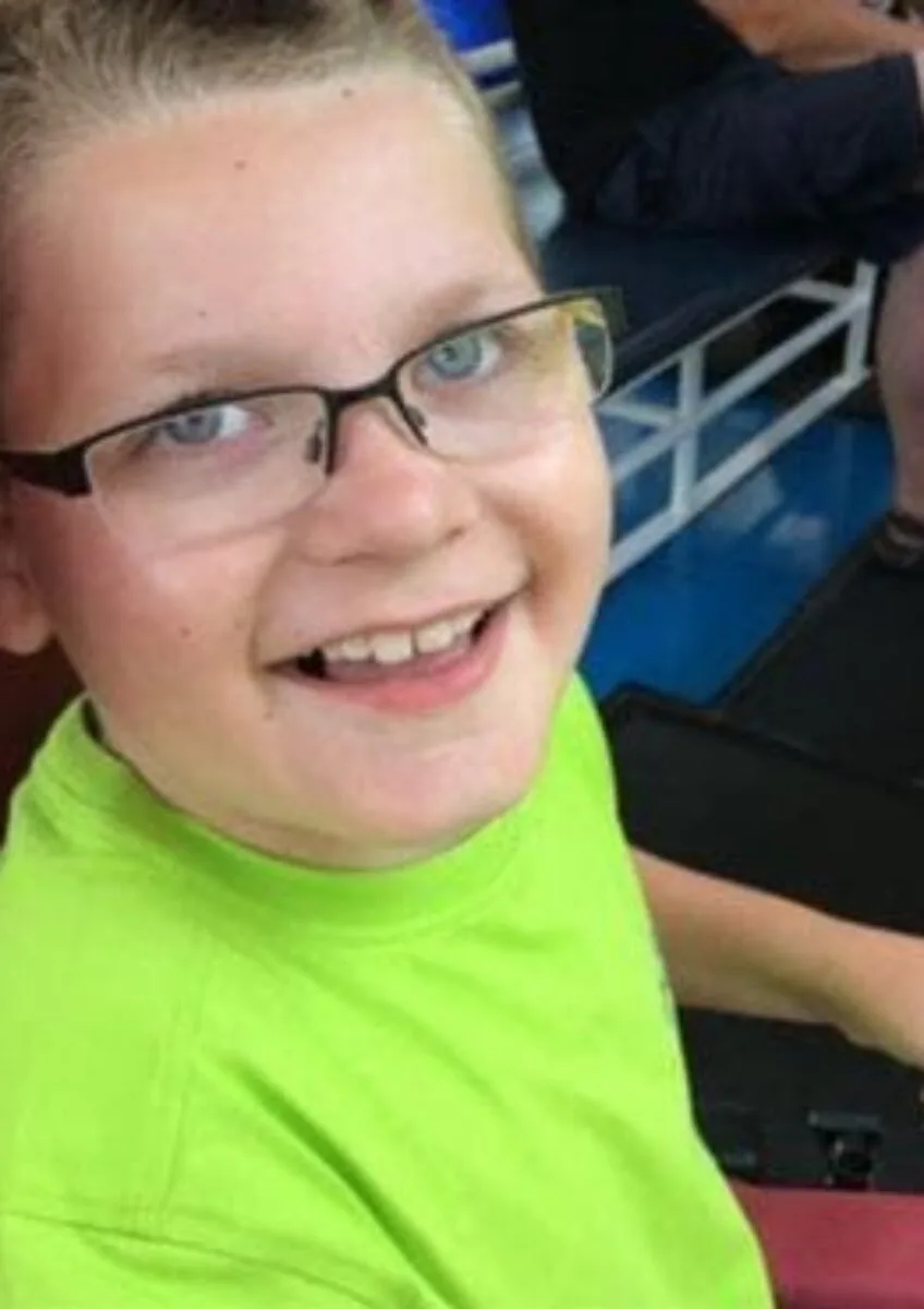 Smiling child with glasses seated indoors