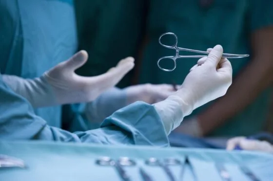 Surgeon holding forceps during operation