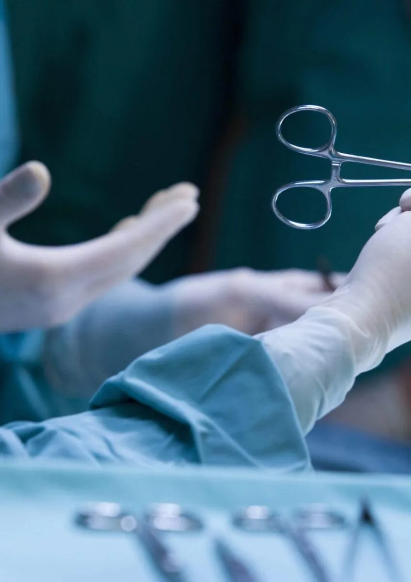 Surgeon holding forceps during operation