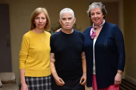 Three people standing together indoors