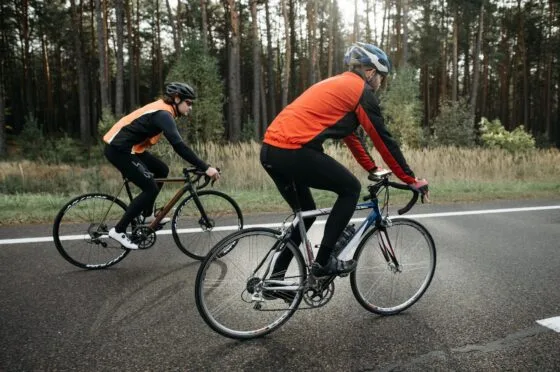 Two cyclists riding on road